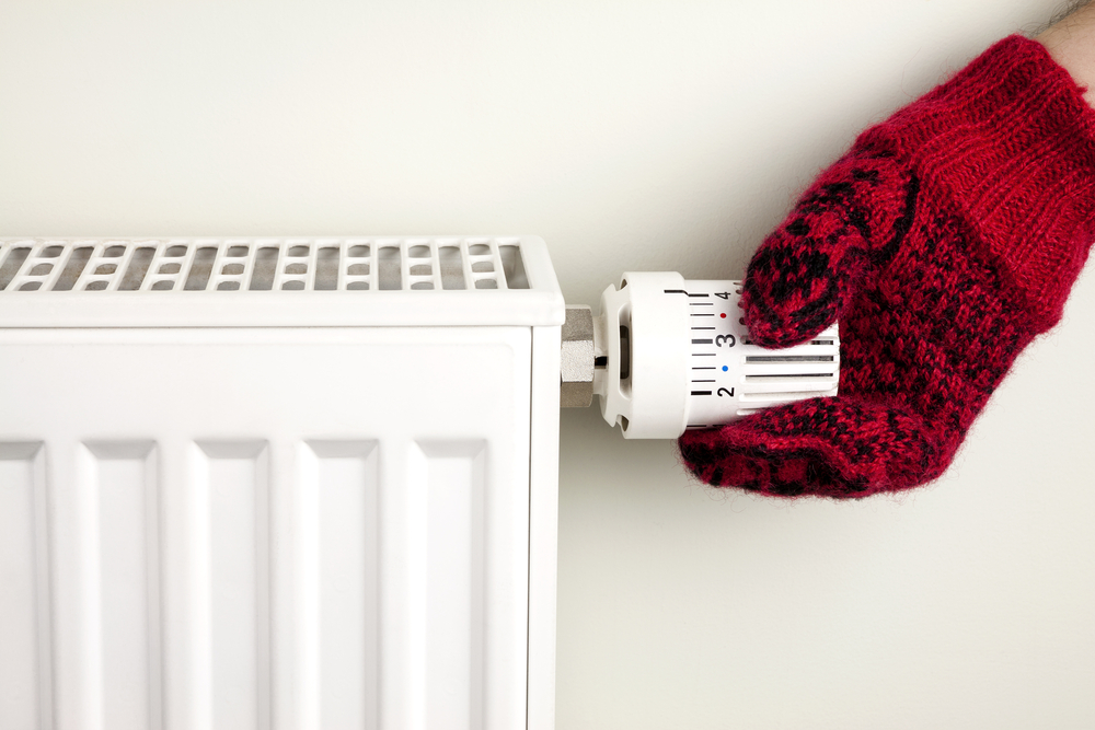 person adjusting heater